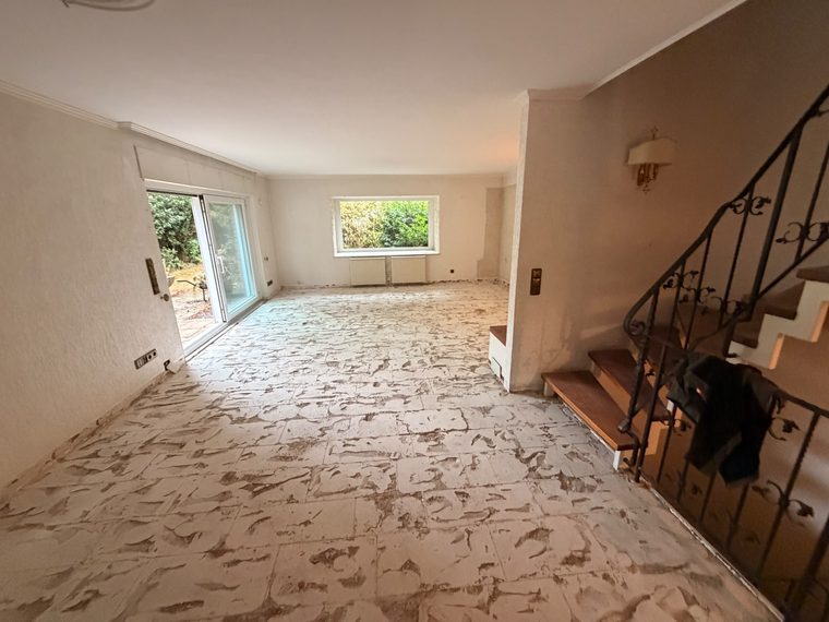 Wohnzimmer zur Terrasse nach dem Rückbau, Bodenfliesen entfernt, Kleberbett liegt frei