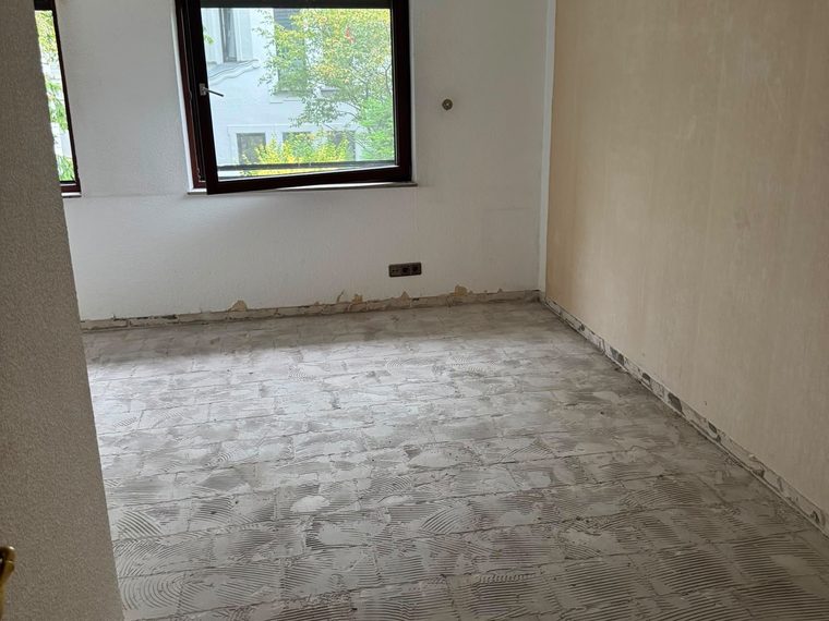 Zimmer zur Straße nach dem Rückbau, Bodenfliesen entfernt, Kleberbett liegt frei